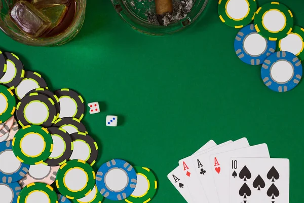 Азартные игры, фортуна и развлекательная концепция - крупный план фишек казино, стаканов виски, игральных карт и сигар на зеленой поверхности стола — стоковое фото