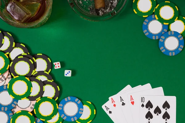 kumar, servet ve eğlence kavramı - casino fişi, viski cam, iskambil ve puro yeşil masa yüzeyi yakın