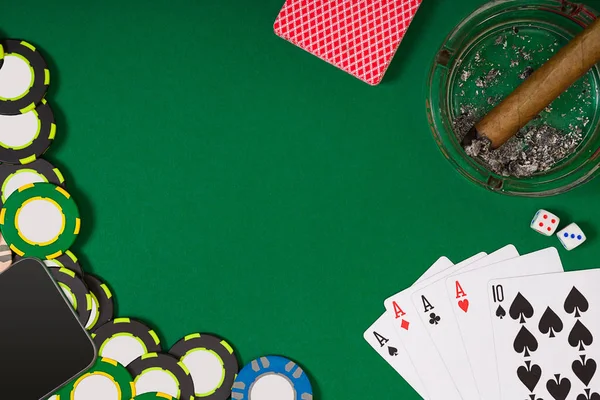 Different color chips for gamblings and playing cards on green — Stock Photo, Image