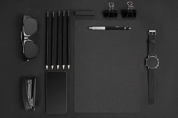 Bloc de notas en blanco con clips, bolígrafos y gafas planas . — Foto de Stock