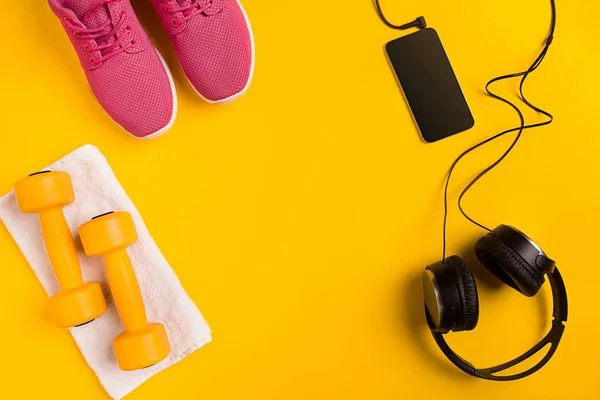 Sportler mit Frauenkleidung, Hanteln und Wasserflasche auf gelbem Hintergrund — Stockfoto