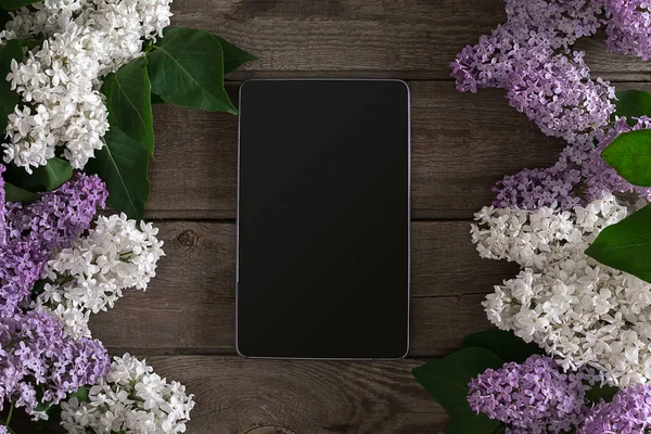 Lilac blossom on rustic wooden background, tablet with empty space for greeting message. Top view — Stock Photo, Image