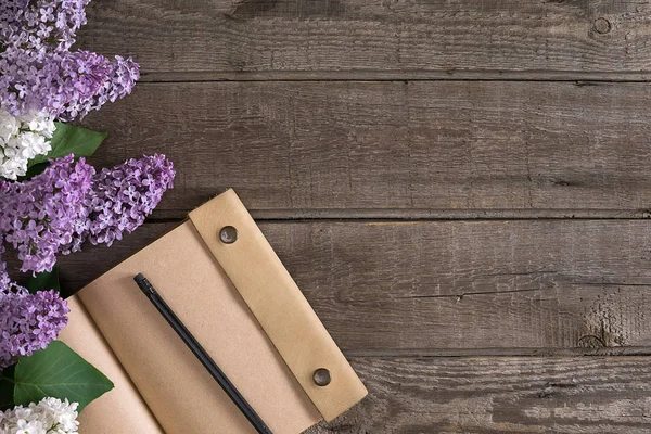 Leylak çiçeği mesaj tebrik için defter rustik ahşap zemin üzerine. Üstten Görünüm