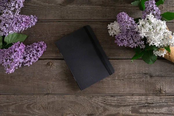 Leylak çiçeği mesaj tebrik için defter rustik ahşap zemin üzerine. Üstten Görünüm