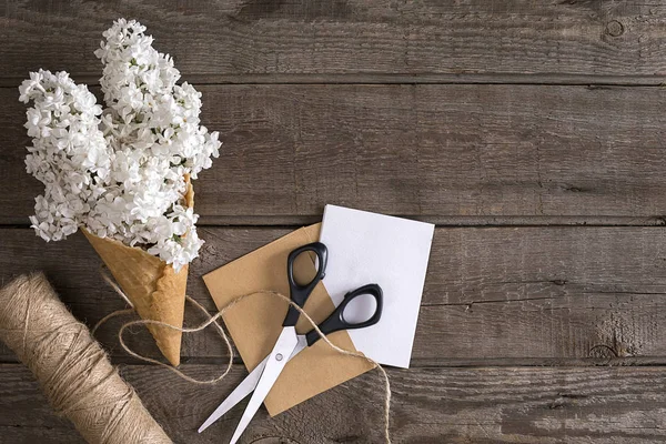 Leylak çiçeği mesaj tebrik için boş alanı rustik ahşap zemin üzerine. Makas, iplik makarası, küçük zarf. Üstten Görünüm