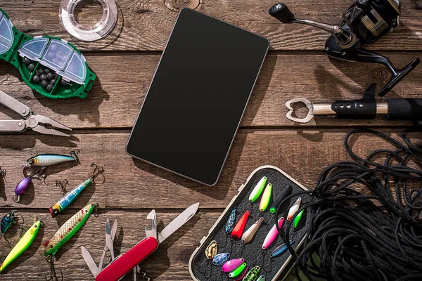 Fishing tackle - fishing spinning, fishing line, hooks and lures on wooden background. — Stock Photo, Image