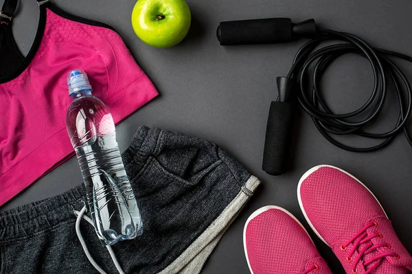 Kadın giyim, spor ayakkabı ve gri arka plan üzerinde su şişe ile sporcular ayarla