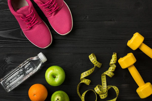 Plano de treino com alimentos e equipamentos de fitness em fundo escuro, vista superior — Fotografia de Stock