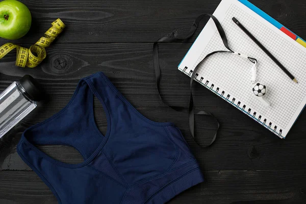 Kadın giyim, spor ayakkabı, şişe su koyu arka plan üzerinde ile sporcular ayarla