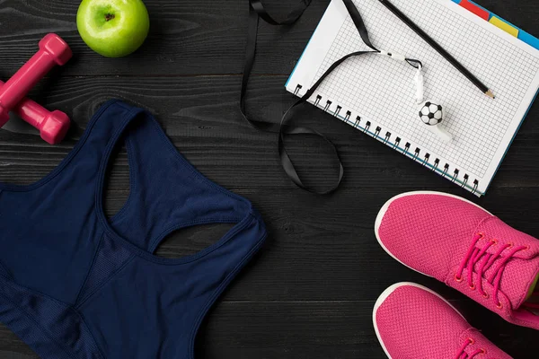Fitness gıda ve ekipmanları egzersiz planı üzerinde koyu arka plan, üstten görünüm
