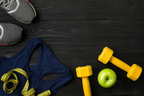 Kadın giyim, spor ayakkabı, şişe su koyu arka plan üzerinde ile sporcular ayarla