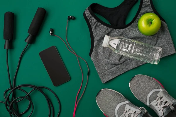 Sporcu kadın giyim ve şişe suyu ile yeşil arka plan ayarla