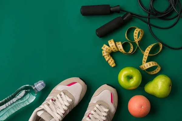 Yeşil arka plan, üstten görünüm üzerinde fitness gıda ve ekipmanları egzersiz planı