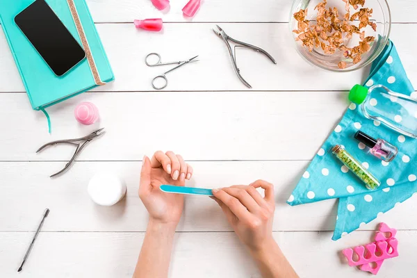 Kadın el bakımı. Profesyonel tırnak bakım araçları ile güzel pürüzsüz kadının el beyaz arka plan üzerinde üstten görünüm koltuklu saç yıkama teknesi.