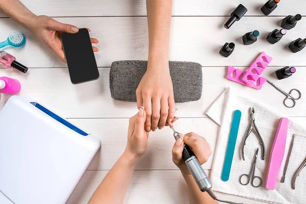Manikür için istemci. Bir manikürcü ve istemci bir ahşap zemin üzerine Close-Up