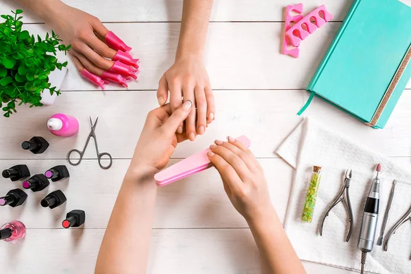 Manikür için istemci. Bir manikürcü ve istemci bir ahşap zemin üzerine Close-Up