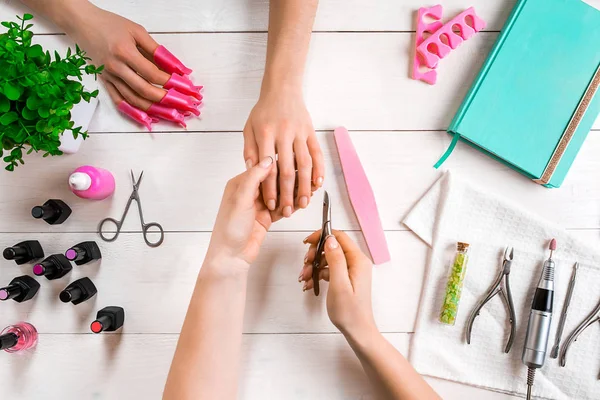 Manikür için istemci. Bir manikürcü ve istemci bir ahşap zemin üzerine Close-Up