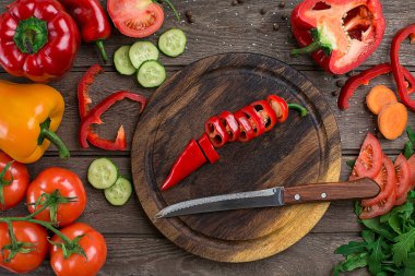 Ahşap bir tahta ve bir tablo üzerinde sebze kesme biber