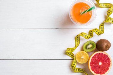 Beyaz ahşap zemin üzerinde şerit metre ile taze meyve. Üstten Görünüm