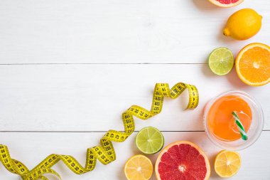 Beyaz ahşap zemin üzerinde şerit metre ile taze meyve. Üstten Görünüm