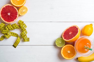 Beyaz ahşap zemin üzerinde şerit metre ile taze meyve. Üstten Görünüm