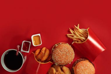 Hamburger ve patates kızartması. Hamburger ve kızarmış patates kırmızı kağıt kutusunda. Fast food kırmızı zemin üzerine.