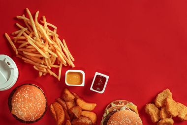 Hamburger ve patates kızartması. Hamburger ve kızarmış patates kırmızı kağıt kutusunda. Fast food kırmızı zemin üzerine.