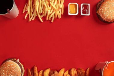 Hamburger ve patates kızartması. Hamburger ve kızarmış patates kırmızı kağıt kutusunda. Fast food kırmızı zemin üzerine.