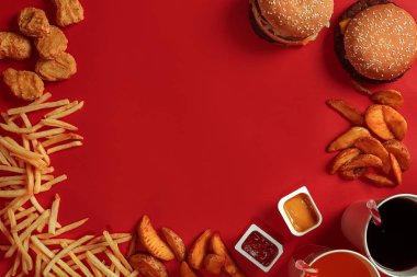 Hamburger ve patates kızartması. Hamburger ve kızarmış patates kırmızı kağıt kutusunda. Fast food kırmızı zemin üzerine.