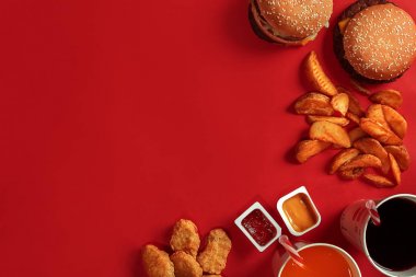 Hamburger ve patates kızartması. Hamburger ve kızarmış patates kırmızı kağıt kutusunda. Fast food kırmızı zemin üzerine.