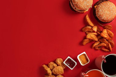 Hamburger ve patates kızartması. Hamburger ve kızarmış patates kırmızı kağıt kutusunda. Fast food kırmızı zemin üzerine.