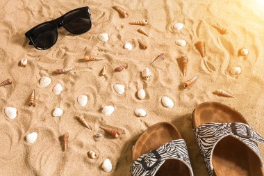 Siyah flip-flop ve sunglass, seashell kum üzerinde. Metniniz için yer ile. Üstten Görünüm