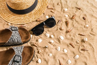 Beachwear, flip flop, şapka, güneş gözlüğü ve kabukları üzerinde kum plaj yaz.