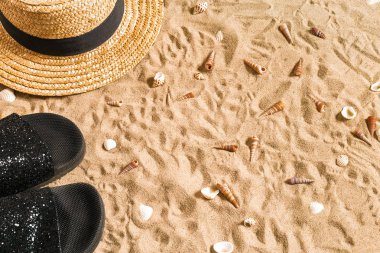 Yaz beachwear, flip flop, şapka ve kabukları üzerinde kum plaj.