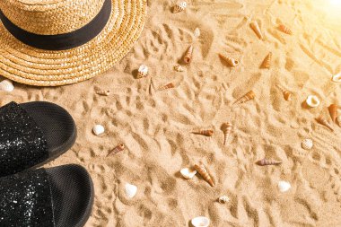 Yaz beachwear, flip flop, şapka ve kabukları üzerinde kum plaj.
