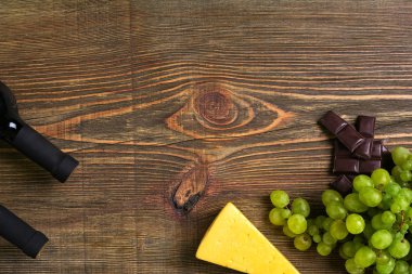 Ahşap arka plan üzerinde olgunlaşmış Üzümler ve şarap şişe