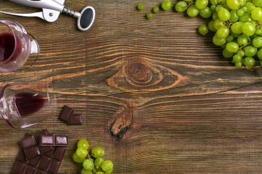 Ahşap bir masaya izole olgun üzüm ve şarap gözlük