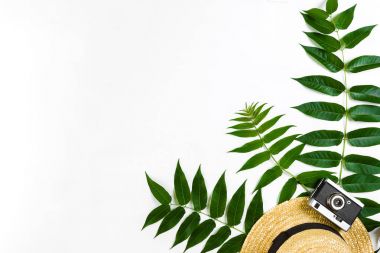 Hasır şapka ile yeşil yaprakları ve beyaz arka plan, yaz arka plan üzerinde eski fotoğraf makinesi. Üstten Görünüm
