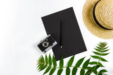 Hasır şapka ile yeşil yaprakları ve beyaz arka plan, yaz arka plan üzerinde eski fotoğraf makinesi. Üstten Görünüm