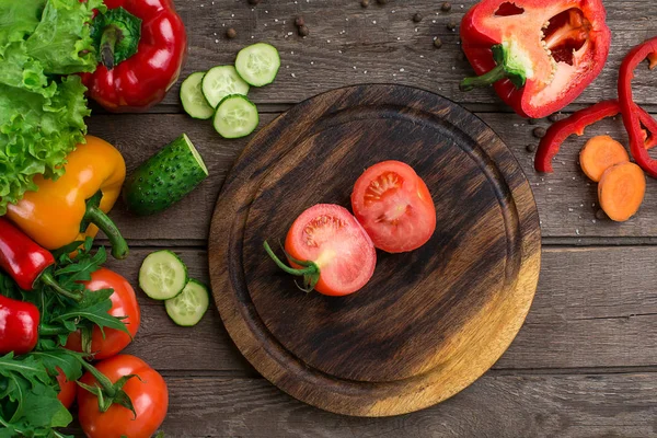 Kesilmiş domates ahşap oyun tahtası ve sebze bir tablo