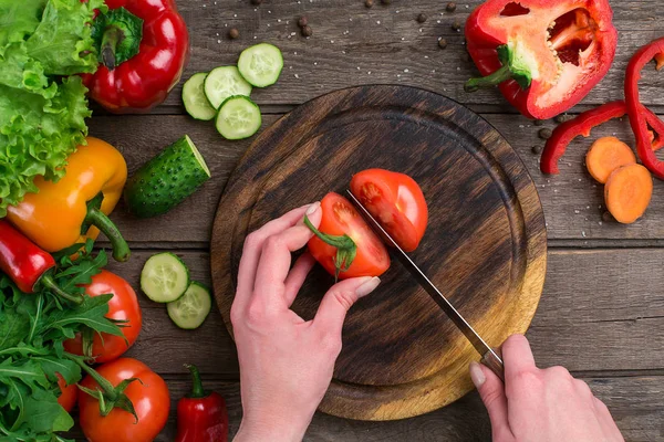 Manos femeninas cortando tomate en la mesa, vista superior — Foto de Stock