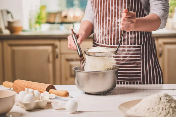 Genç kadın holding kase hamur ve çırpma teli, closeup ile
