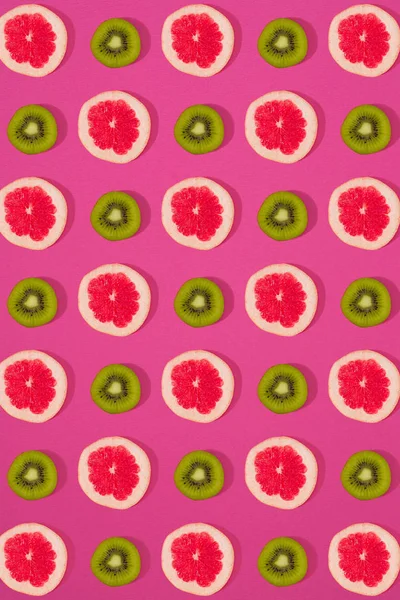 葡萄柚和猕猴桃模式在粉红色的背景上。最小的平躺概念. — 图库照片
