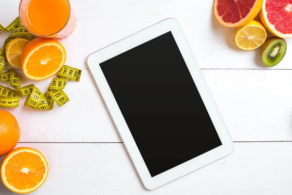 Vers sap in glas van citrusvruchten - citroen, grapefruit, sinaasappel, tablet op witte houten achtergrond — Stockfoto