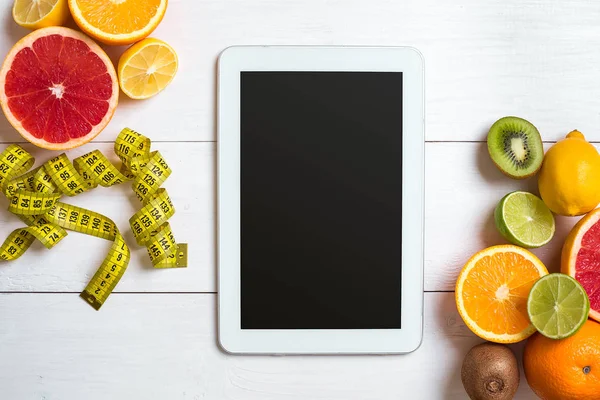 Beyaz ahşap zemin üzerinde şerit metre ile taze meyve. Üstten Görünüm