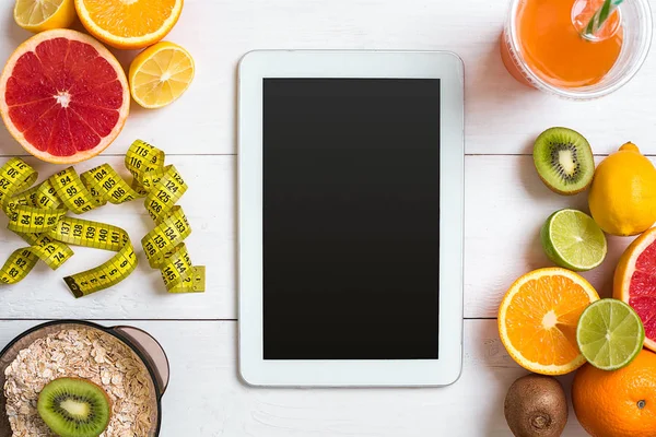 Beyaz ahşap zemin üzerinde şerit metre ile taze meyve. Üstten Görünüm