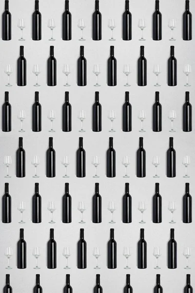 Temné láhve vína a skleničky. Creative tmavé a matné abstraktní pozadí. — Stock fotografie