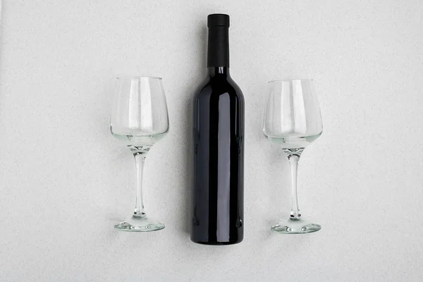 Büyük bir şişe kırmızı şarap, beyaz arka plan üzerinde gözlük içme genel gider açılı görünümü — Stok fotoğraf