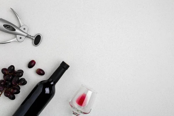 Büyük bir şişe kırmızı şarap, beyaz arka plan üzerinde cam içme görünümünü yükü açılı — Stok fotoğraf