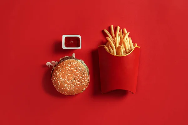 Hamburger e patatine. Hamburger e patatine fritte in scatola di carta rossa. Fast food su sfondo rosso . — Foto Stock